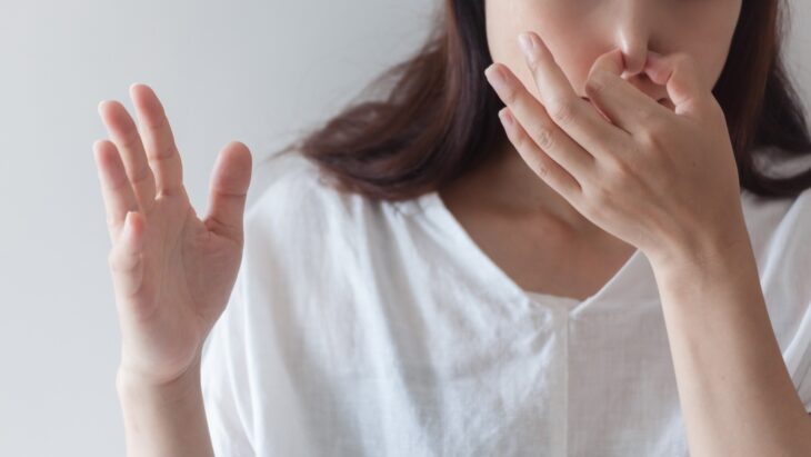 悪臭に鼻をつまむ女性