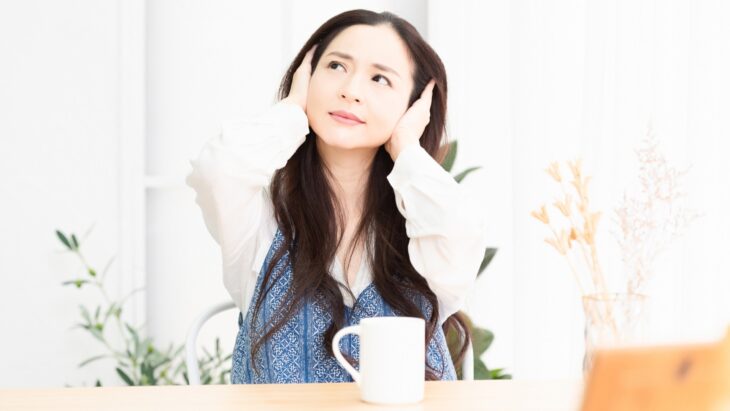 騒音に耳を塞ぐ女性